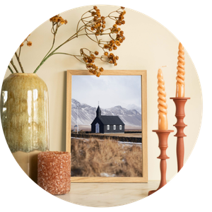 Moderne poster van de beroemde zwarte kerk Budakirkja in IJsland in een ruig landschap, sfeervol opgehangen in een Scandinavisch interieur.