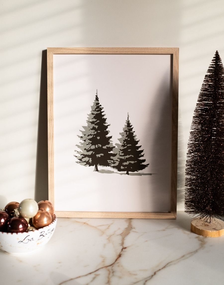 Ingelijste kerstposter met een illustratie van twee dennenbomen op een marmeren ondergrond, naast een schaaltje met kerstballen en een mini kerstboom.