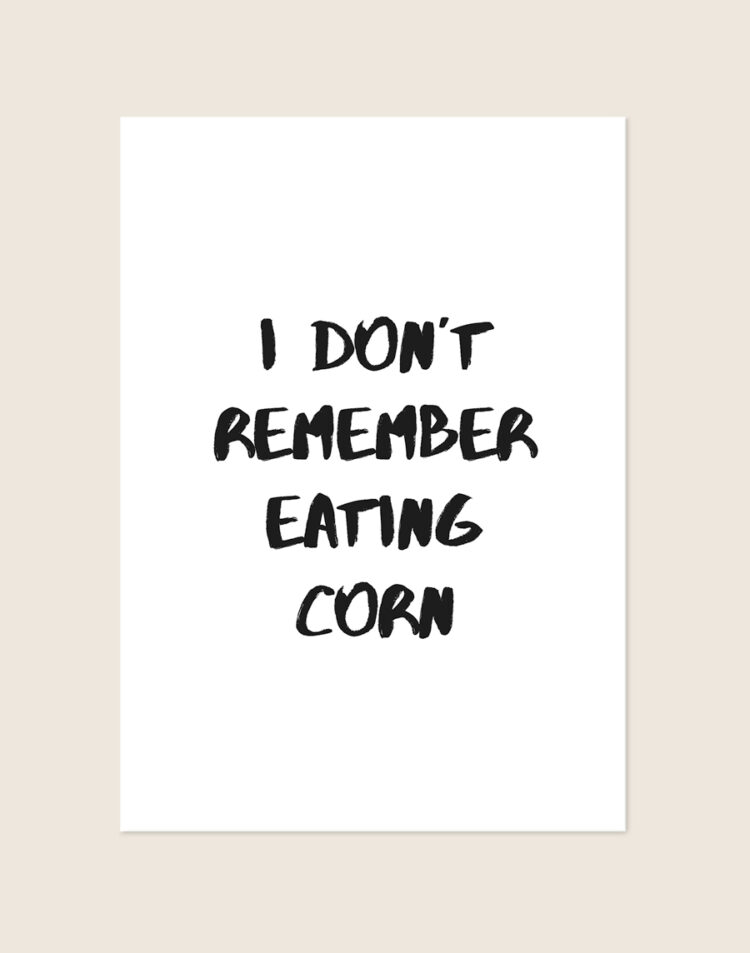 Minimalistische zwart-witte Corn poster met de tekst I DON'T REMEMBER EATING CORN in stoere brush-letters, sfeervol opgehangen in een toiletruimte.