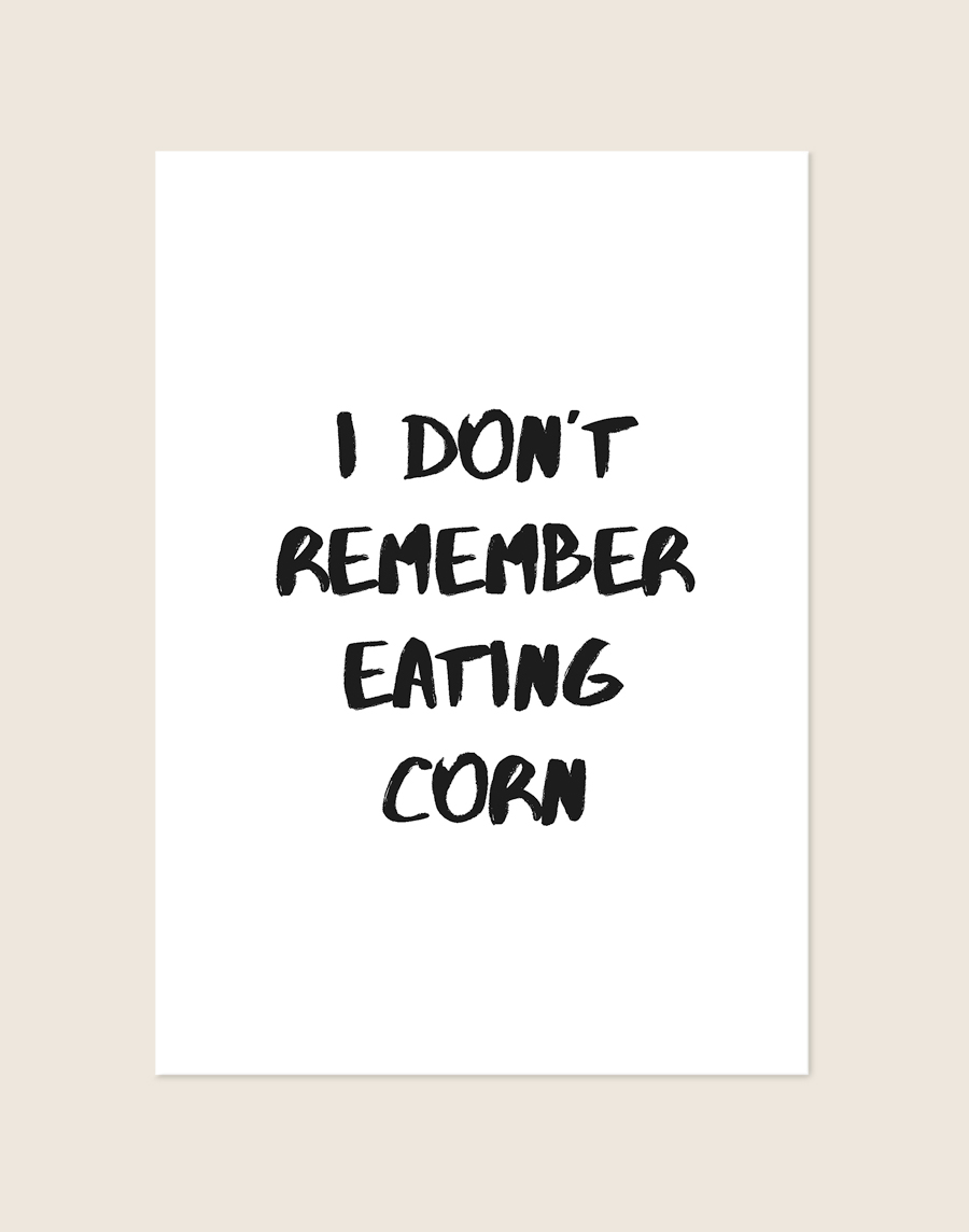 Minimalistische zwart-witte Corn poster met de tekst I DON'T REMEMBER EATING CORN in stoere brush-letters, sfeervol opgehangen in een toiletruimte.