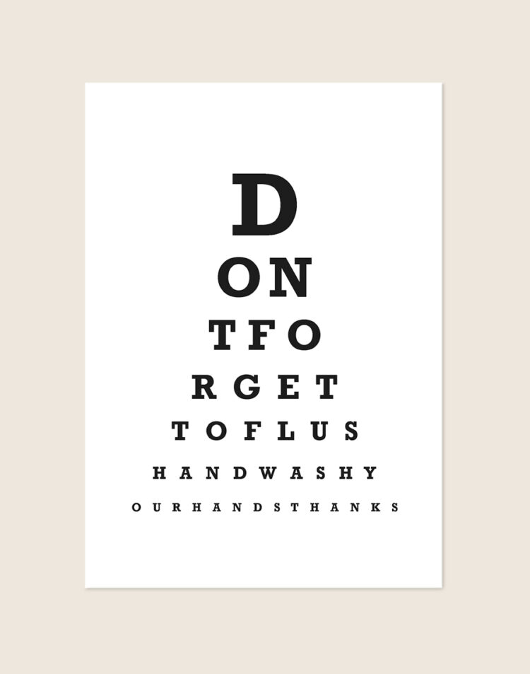 Minimalistische zwart-witte Don't forget poster in het ontwerp van een oogtest, sfeervol opgehangen aan een muur in een moderne toiletruimte.