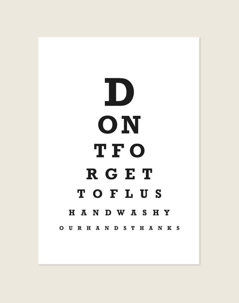 Minimalistische zwart-witte Don't forget poster in het ontwerp van een oogtest, sfeervol opgehangen aan een muur in een moderne toiletruimte.