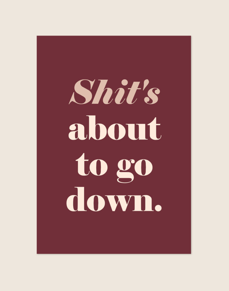 Chique bordeauxrode typografische poster met de beige tekst Shit's about to go down, sfeervol opgehangen aan een neutrale muur in een moderne toiletruimte.