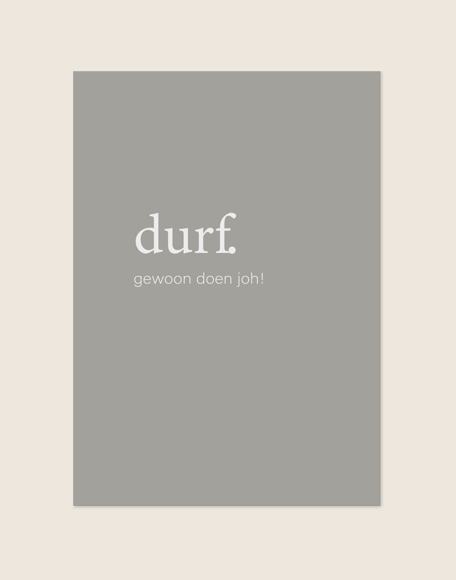 Minimalistische grijze Poster Durf met witte letters en de Nederlandse tekst durf. gewoon doen joh!, sfeervol opgehangen in een ruimte.