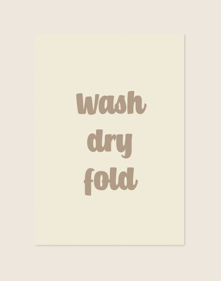 Sfeervolle crèmekleurige Fold poster met taupebruine letters en de tekst wash dry fold, sfeervol opgehangen in een stijlvolle wasruimte.