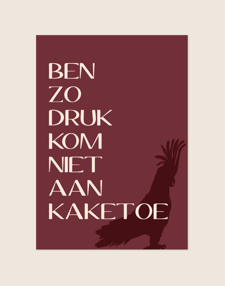 Chique bordeauxrode typografische poster met beige tekst Ben zo druk kom niet aan kaketoe en een kaketoe silhouet, sfeervol opgehangen in een moderne toiletruimte.