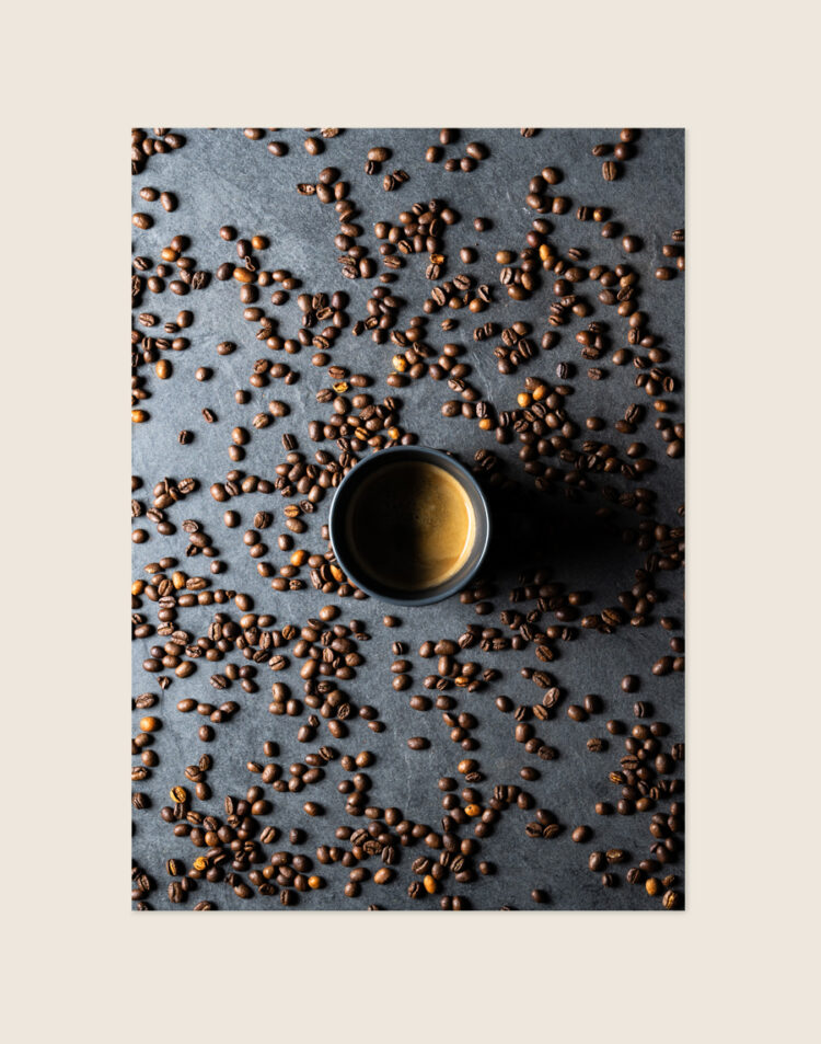 Stijlvolle grafische poster met een afbeelding van koffiebonen, sfeervol opgehangen aan een neutrale muur bij een koffiecorner in een moderne keuken.