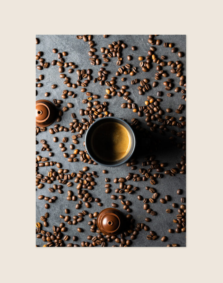 Stijlvolle grafische poster met een afbeelding van kleurrijke koffiecups, sfeervol opgehangen aan een neutrale muur bij een koffiecorner in een moderne keuken.