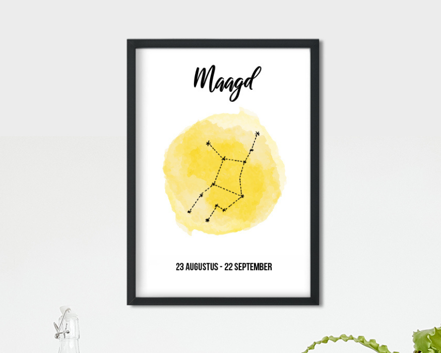 Een ingelijste poster op een helderwitte achtergrond. In de strakke zwarte fotolijst zit een poster met bovenaan de tekst 'Maagd' in een sierlijk, handgeschreven zwart lettertype. In het midden staat een heldergele aquarel vlek met daarin de sterrenconstellatie van de Maagd weergegeven met zwarte lijntjes en sterretjes. Onderaan staat in strakke zwarte letters de datum '23 AUGUSTUS - 22 SEPTEMBER'. Linksonder in beeld is de bovenkant van een glazen fles met beugelsluiting zichtbaar en rechtsonder steken de bladeren van een groene plant in beeld.