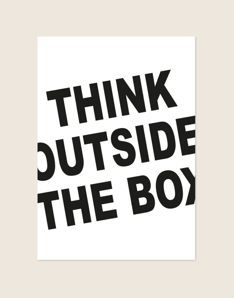 Minimalistische zwart-witte Poster Outside the box met vette schuingeplaatste letters die buiten de randen vallen met de tekst THINK OUTSIDE THE BOX, sfeervol opgehangen in een werkkamer.