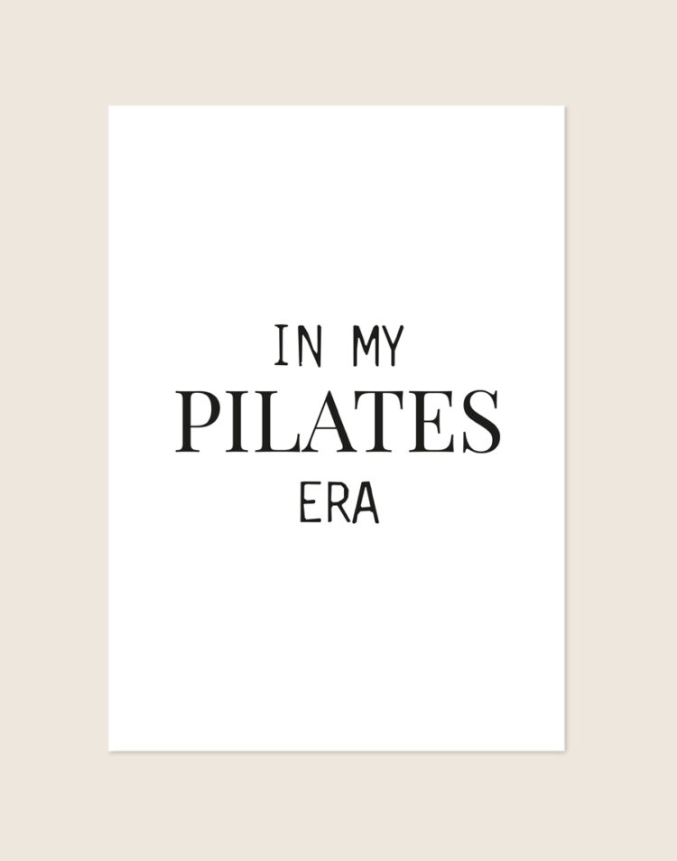 Een strakke, minimalistische witte poster met de quote "IN MY PILATES ERA" in een speelse combinatie van klassieke en strakke zwarte letters.