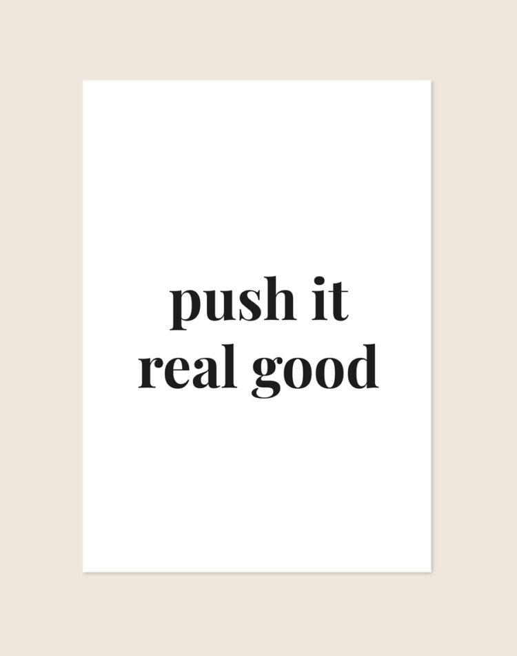 Minimalistische zwart-witte Push it poster met de tekst push it real good in elegante schreefletters, sfeervol opgehangen in een toiletruimte.