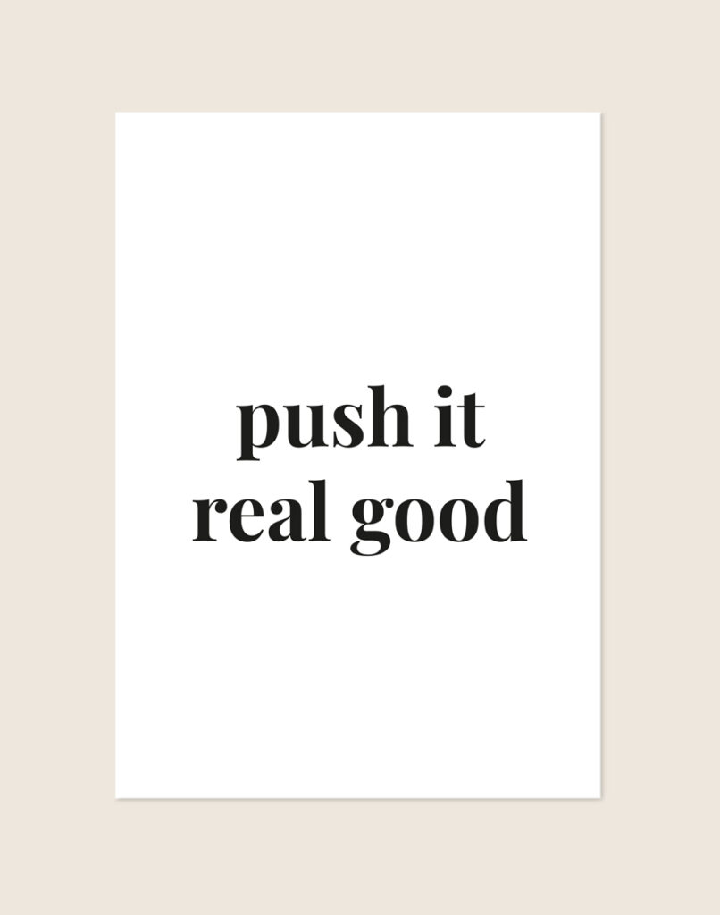 Minimalistische zwart-witte Push it poster met de tekst push it real good in elegante schreefletters, sfeervol opgehangen in een toiletruimte.