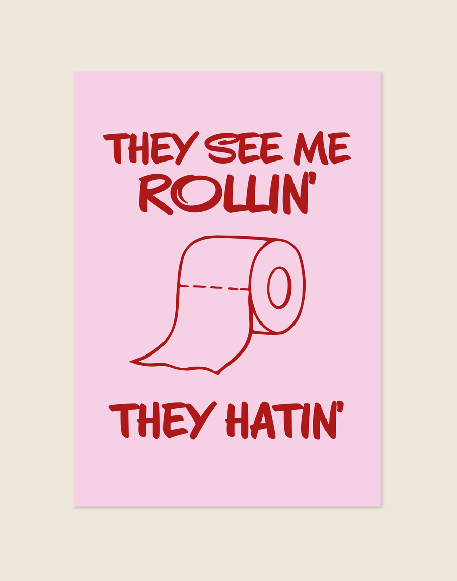 Grappige roze poster met de tekst 'They see me rollin', they hatin' en een illustratie van een wc-rol, sfeervol opgehangen aan een neutrale muur in een moderne toiletruimte.