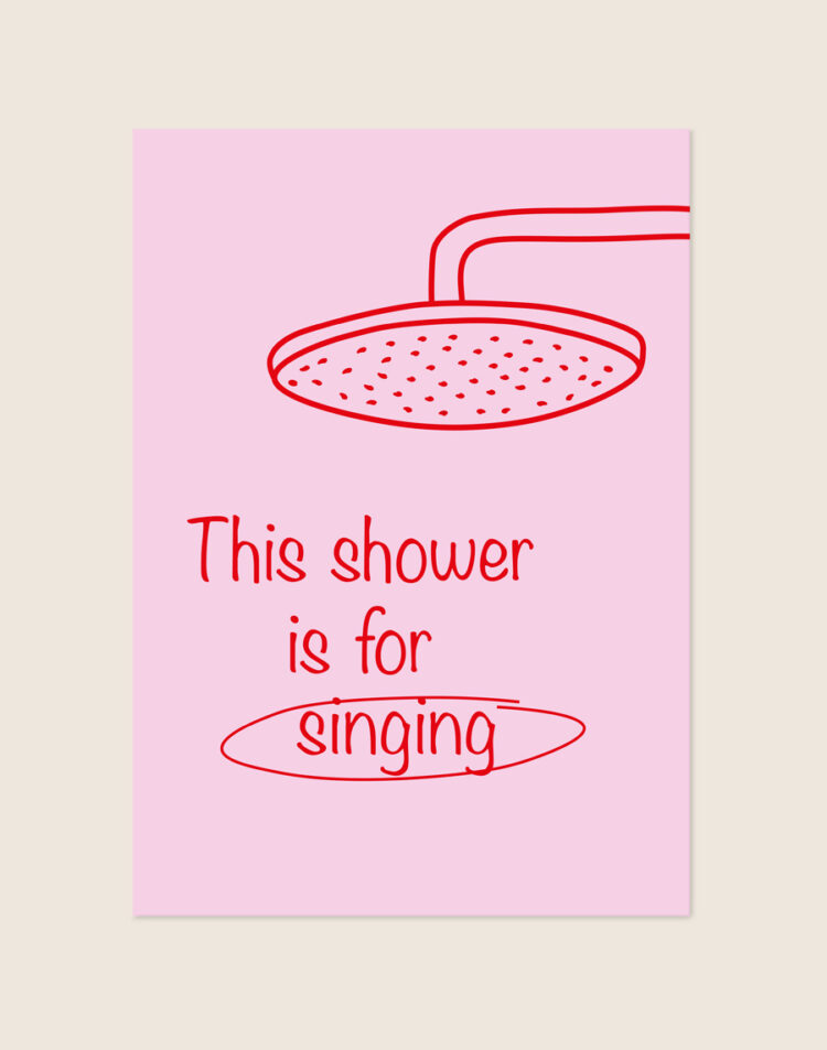 Vrolijke roze poster met een rode douchekop illustratie en de tekst This shower is for singing, sfeervol opgehangen aan een neutrale muur in een moderne badkamer.
