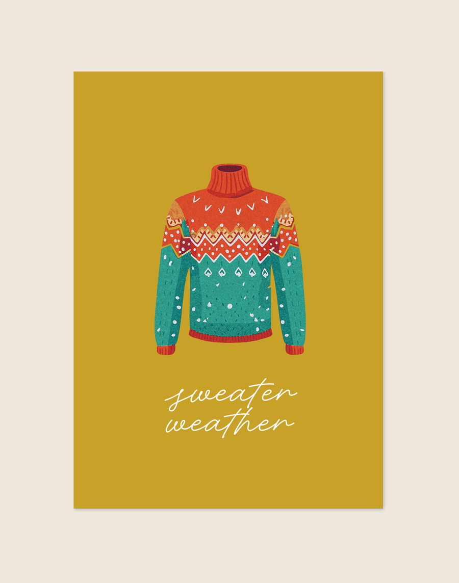 Okergele poster met een illustratie van een kleurrijke, gebreide wintertrui in rood en groenblauw, met de witte sierlijke tekst 'sweater weather', sfeervol opgehangen in een knusse woonkamer.