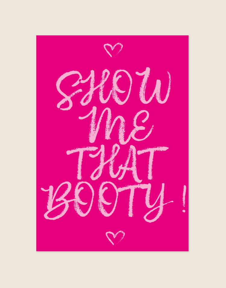 Felle magentaroze poster met lichtroze handgeschreven letters met de tekst SHOW me THAT BOOTY! en twee hartjes, sfeervol opgehangen aan een neutrale muur in een moderne toiletruimte.