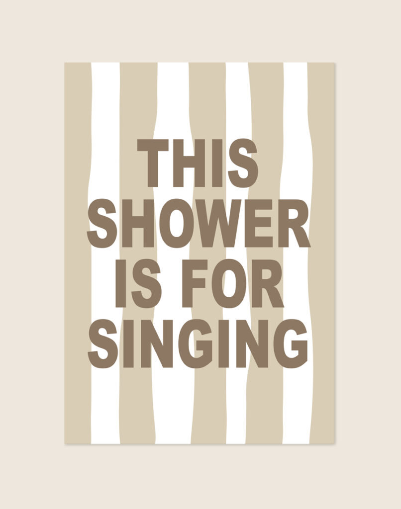 Stijlvolle typografische poster met beige-witte strepen en bruine tekst This shower is for singing, sfeervol opgehangen aan een neutrale muur in een moderne badkamer.