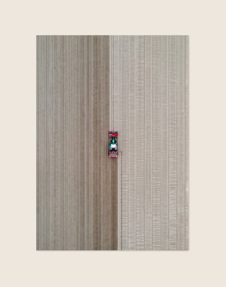 Stoere poster van een authentieke tractor in een landelijke omgeving, sfeervol opgehangen in een industrieel interieur.