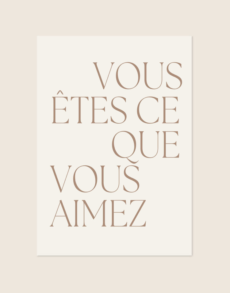Minimalistische crèmekleurige poster met de taupekleurige Franse tekst 'VOUS ÊTES CE QUE VOUS AIMEZ' in een slank schreeflettertype.