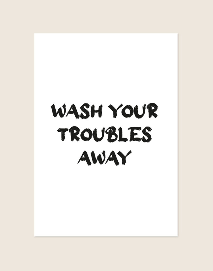 Rustgevende badkamer Poster Wash troubles away met de Engelse quote in zwarte kwaststreken op een helderwitte achtergrond, sfeervol opgehangen in een ruimte.