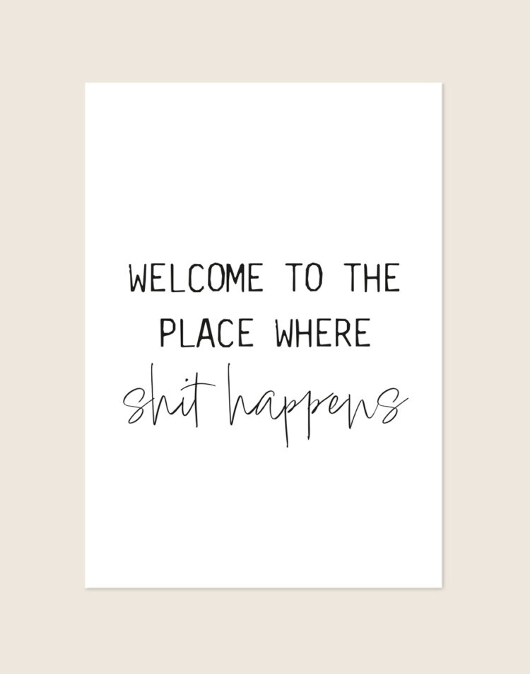 Minimalistische zwart-witte Welcome poster met de tekst Welcome to the place where shit happens in strakke en sierlijke letters, sfeervol opgehangen in een toiletruimte.