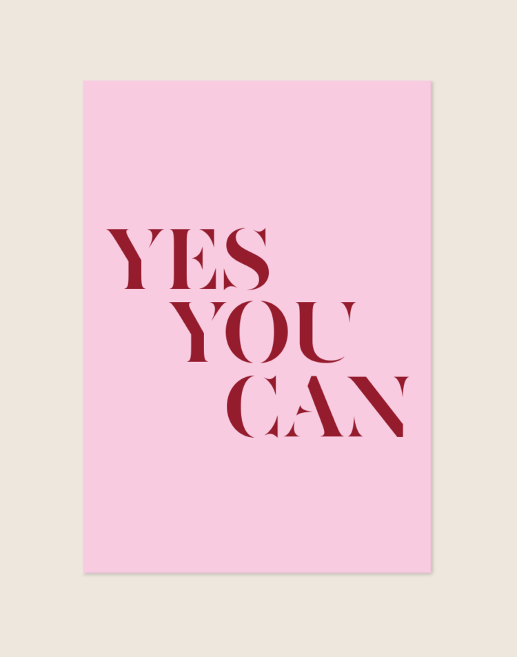 Een rechthoekige poster, gecentreerd tegen een effen, lichtbeige achtergrond. De poster zelf heeft een zachte, lichtroze achtergrondkleur. In het midden staat de motiverende quote 'YES YOU CAN' geschreven in grote, bordeauxrode letters. De woorden staan onder elkaar gepositioneerd, maar verspringen speels trapsgewijs naar rechts. Het lettertype is modern, elegant en heeft een sterk contrast tussen hele dikke en hele dunne lijnen (een high-contrast serif of stencil lettertype), wat het ontwerp een chique en stijlvolle uitstraling geeft.