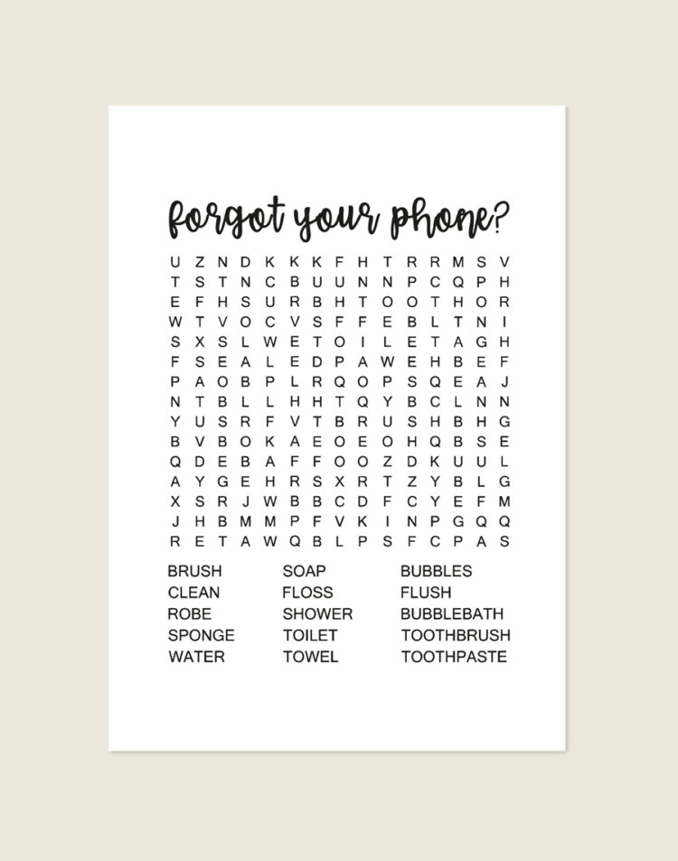 Minimalistische zwart-witte poster met een zwarte woordzoeker en de tekst forgot your phone?, sfeervol opgehangen aan een neutrale muur in een moderne toiletruimte.
