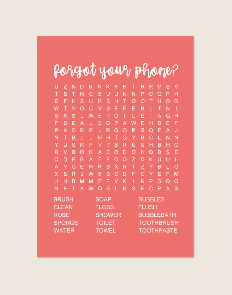 Vrolijke koraalrode poster met een witte woordzoeker en de tekst forgot your phone?, sfeervol opgehangen aan een neutrale muur in een moderne toiletruimte.
