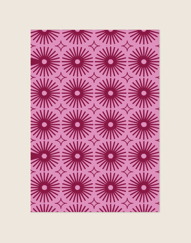 Kleurrijke retro poster met een geometrisch, herhalend patroon van magenta zonnen en sterren op een zachtroze achtergrond, sfeervol opgehangen in een eclectisch interieur.