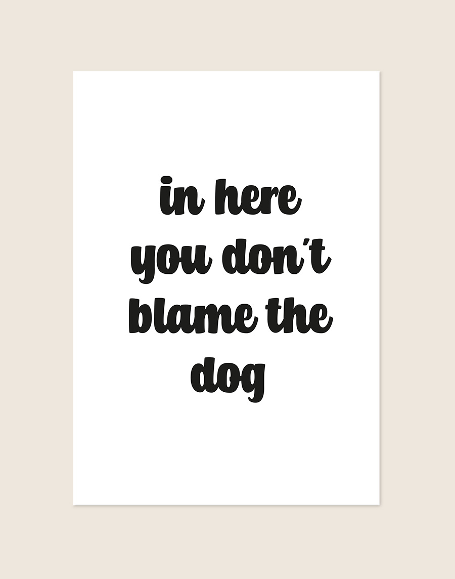 Humoristische WC Poster Blame the dog met de Engelse quote "in here you don't blame the dog" in zwarte afgeronde letters op een helderwitte achtergrond, sfeervol opgehangen in een ruimte.