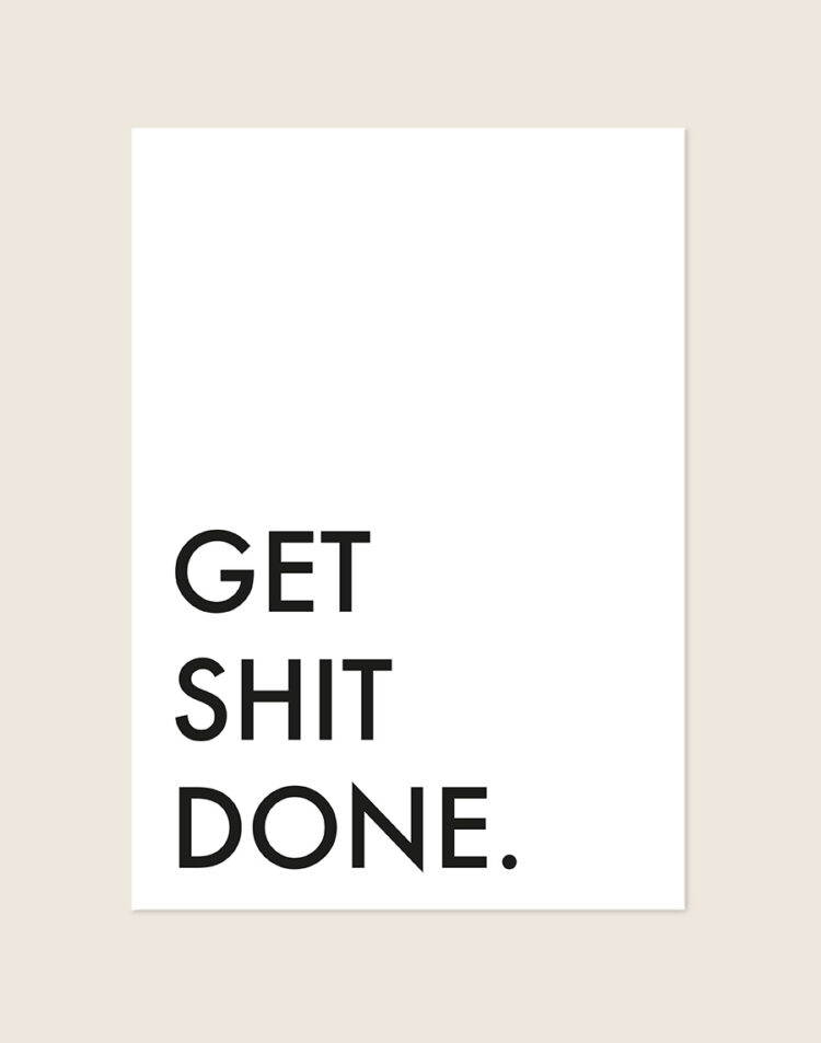 Minimalistische Poster Get shit done met strakke zwarte letters en veel witruimte op een helderwitte achtergrond, sfeervol opgehangen in een ruimte.