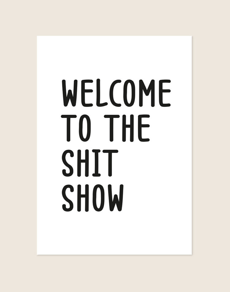 Humoristische WC Poster Shit show met de tekst Welcome to the shit show in zwarte handgetekende letters op een helderwitte achtergrond, sfeervol opgehangen in een ruimte.